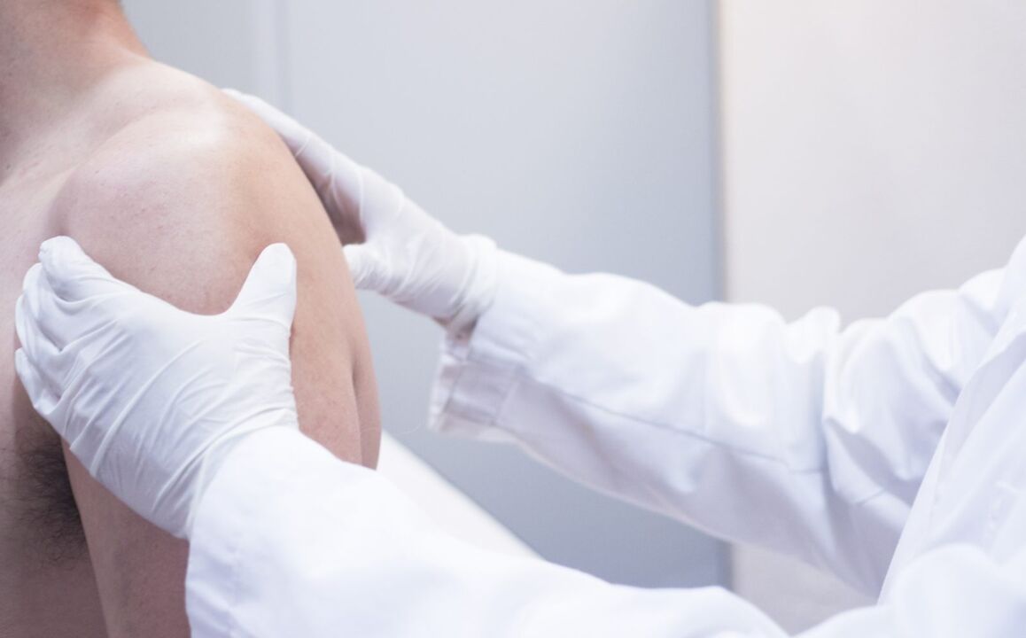 the doctor examines the shoulder with arthrosis